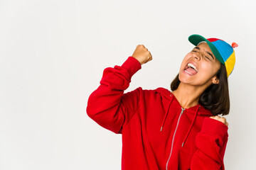 Young hispanic woman wearing a cap with propeller isolated raising fist after a victory, winner concept.