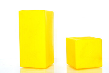 Abstract wallpaper. 3D geometric cubic yellow shapes - parallelepiped and cube with reflection in glass surface isolated on white background