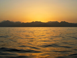 Sunrise over Dominica, Caribbean island coasts seen from a charter boat.