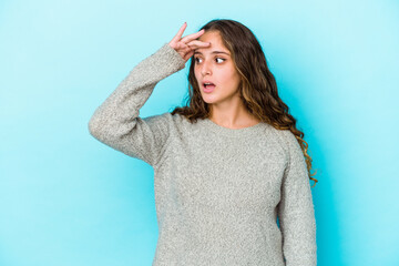 Young caucasian curly hair woman isolated looking far away keeping hand on forehead.