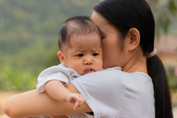 Young Asian mother holding little daughter in the park, Mother play enjoying with her cute baby girl  outdoor, copy space
