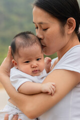 Young Asian mother holding little daughter in the park, Mother play enjoying with her cute baby girl  outdoor, copy space

