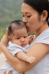 Young Asian mother holding little daughter in the park, Mother play enjoying with her cute baby girl  outdoor, copy space
