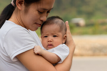 Young Asian mother holding little daughter in the park, Mother play enjoying with her cute baby girl  outdoor, copy space
