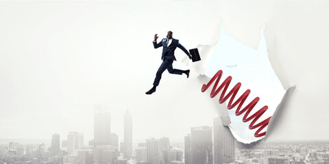 Businessman jumping on springboard . Mixed media
