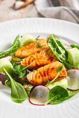 Salmon Salad with Fresh Vegetables. White plate with healthy fish food on wooden table. Healthy, Vegetarian, Restaurant rustic food concept.