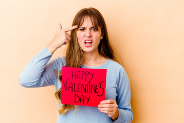 Fototapeta na wymiar Young caucasian woman holding a Happy Valentines day isolated showing a disappointment gesture with forefinger.