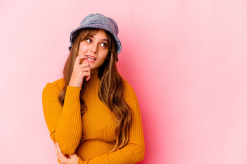 Naklejka premium Young caucasian woman wearing fishermans hat isolated relaxed thinking about something looking at a copy space.