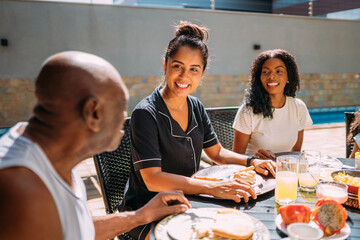 Happy Latinx family having breakfast at home.
