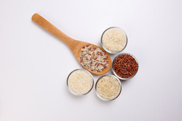 Long grain basmati medium grain jasmine short grain pilaf polau risotto brown low glycaemic index gi rice in small glass bowl wooden spoon on white background copy text space top flat lay view