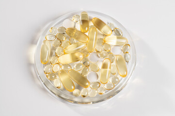 set of vitamin D, omega 3-6-9, zinc, yellow capsules on a white background