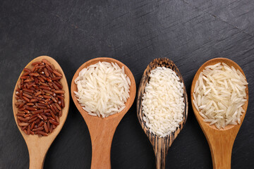 Long grain basmati medium grain jasmine short grain pilaf polau risotto brown low glycaemic index gi rice in wooden spoon on black background copy text space top flat lay view