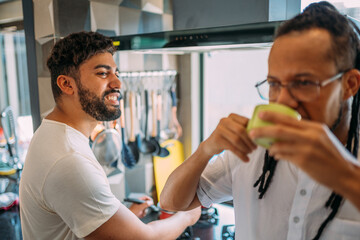 Fototapeta premium gay young latinx couple together in the kitchen, having a great time
