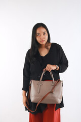 Young woman in casual outfit with stylish bag on white background.