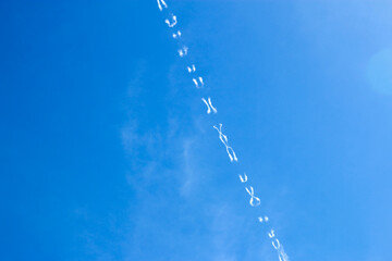 White trail left by the airplane in the sky shaped like XOXO