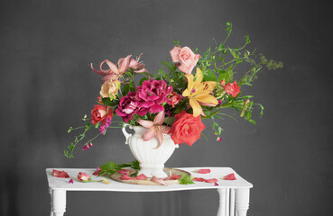 bouquet of summer flowers in vase on vintage white wooden shelf on dark background