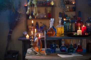Fototapeta na wymiar magic potions in witch's house with burning candles at night
