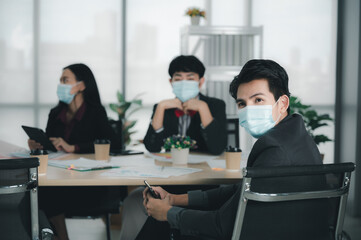 Group of young business people sit at their desks with smiling colleagues together in the office.  Meeting business people  planning concept, laptop meeting ideas. Concentrate on work. LGBT teamwork.