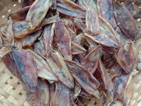 Dried squid, clean fresh seafood in wicker basket background closeup, delicious Thai food snack.