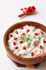 Indian Fresh sauce or condiment called Raita. Yogurt mixed with grated cucumber, onions,  pomegranate and spices. Garnished with fresh coriander. Copy space.