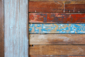 Wooden wall with vertical and horizontal painted old timbers.