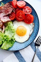 fried eggs with bacon and vegetables