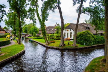 Fototapeta na wymiar Giethoorn, Netherlands - July 6, 2019: The canals of Giethoorn, a scenic village in the Netherlands, known as the Venice of the North