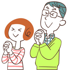 目を瞑って祈る夫婦
