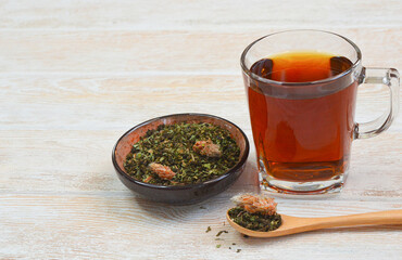 Granulated ivan tea with sea buckthorn berries and lingonberry leave on wooden table. Drink kopor tea with pleasant, rich taste. Copy space text