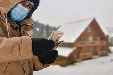 Man in medical mask buying mountain cottage during coronavirus epidemic