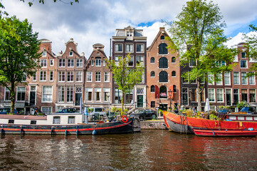Amsterdam, Netherlands - July 7, 2019: Traditional Dutch houseboats docked in the canals of Amsterdam in the Netherlands