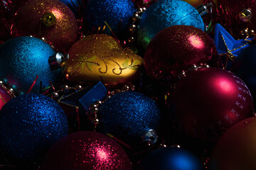 Amazing Christmas composition with gold, blue and red christmas balls. Christmas or New Year concept. Dark festive background with baubles, stars, hearts. 