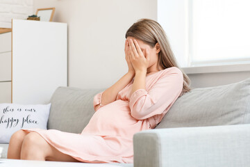 Stressed pregnant woman at home