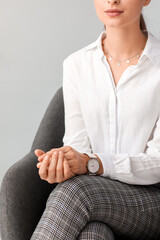 Woman with stylish wrist watch on light background