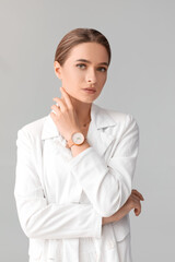 Woman with stylish wrist watch on light background