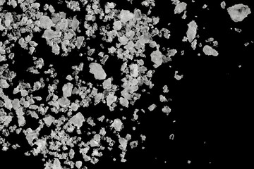 Pieces of  white sea salt on a black background. clear crystalline pebbles. white ice cubes