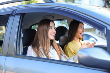 Happy young women sitting in car
