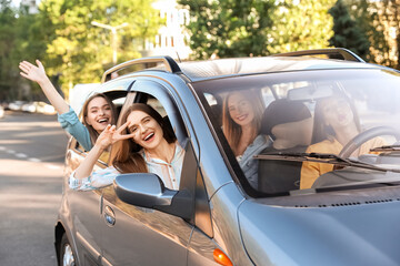 Happy young women traveling by car