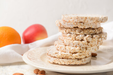 Plate with rice crackers on light background