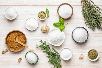 Composition with different spices and herbs on light wooden background