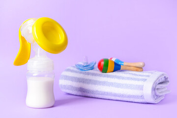 Breast pump and baby accessories on color background