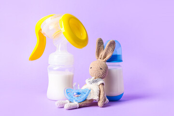 Breast pump and baby accessories on color background