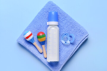Bottle of milk for baby and accessories on color background