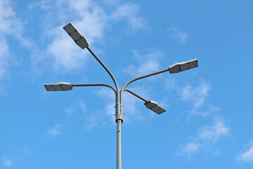 Led lamps on blue sky and white clouds background. Electric lighting, energy-saving street lantern