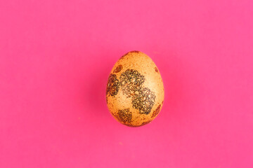 Easter egg painted orange with gold. One painted easter egg on a pink background.Flat lay. Copy space.