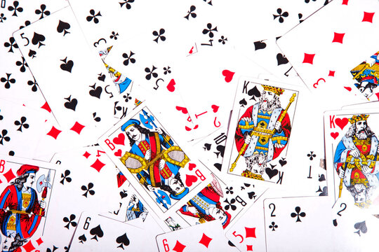 Playing cards are scattered on table. Background of scattered deck of cards filling entire space of image. Top view, close-up. Copyright space for site or logo