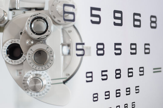 Close Up Of Phoropter Eyesight Measurement Testing Machine With Double Exposure Test Chart Vision Optician Check Up Number, Eye Health Check And Ophthalmology Concept.