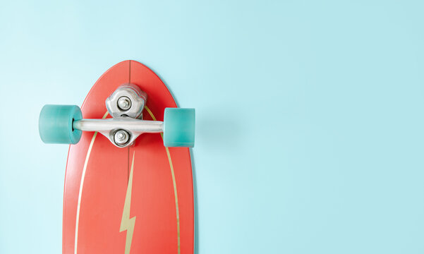 Minimal red surf skate or skateboard on blue color background. Sport activity lifestyle concept, Copy space.
