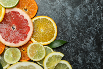 Ripe citrus slices on black smoky background