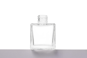 transparent bottle made of white glass on a gray base, isolate on a white background